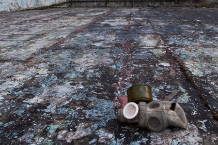 The old gas mask lies on a destroyed concrete floor, a symbol of the horrors of nuclear war and...