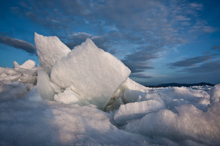 Ice hummocks pile fancifully on top of each other blue-turquoise ice of Baikal and the sky...