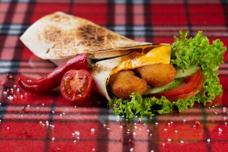 roll with chicken nuggets, fresh vegetables, cheese, chili peppers and cherry tomatoesの写真素材