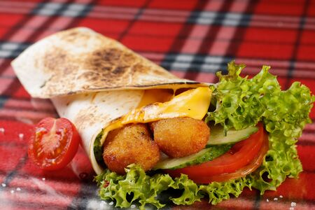 roll with chicken nuggets, fresh vegetables, cheese, chili peppers and cherry tomatoesの写真素材