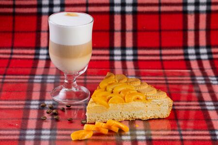 hot coffee with latte milk with a delicious dessert of apricots and peachesの写真素材
