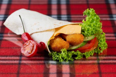roll with chicken nuggets, fresh vegetables, cheese, chili peppers and cherry tomatoesの写真素材