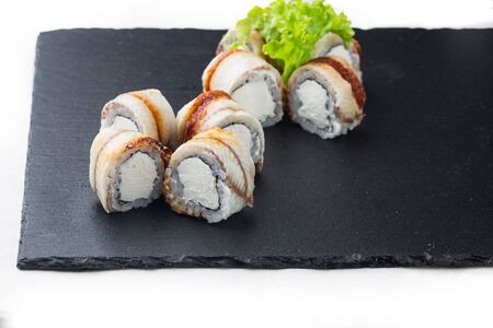 maki sushi with eel and soft cheese on a stone board. on a white backgroundの写真素材