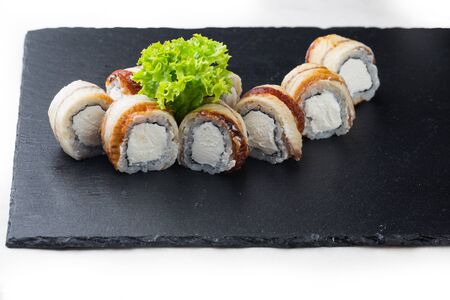 maki sushi with tuna, soft cheese and balsamic sauce on a stone board. on a white backgroundの写真素材