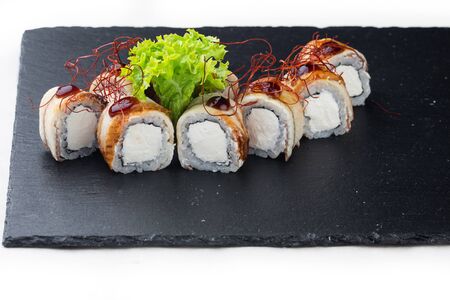 maki sushi with tuna, soft cheese and balsamic sauce on a stone board. on a white backgroundの写真素材