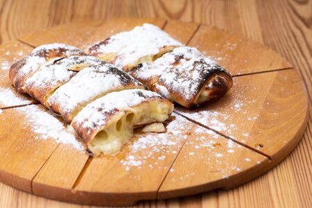 fruit strudel on a wooden board sprinkled with icing sugar. delicious pastriesの写真素材