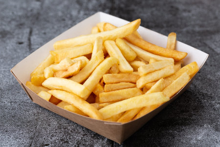 fries on a stone plate. french fries in disposable dishes