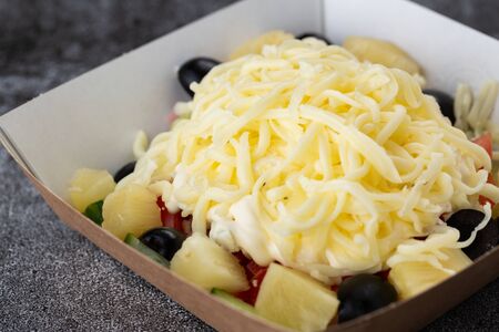 salad of fresh vegetables from tomatoes, cucumbers, olives and pineapples. salad with mayonnaise and cheeseの写真素材