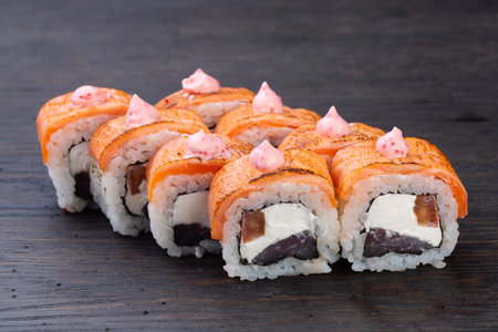 traditional Japanese sushi with salmon, soft cheese, avocado and red caviar, garnished with creamy sauce. Japanese kitchen. Japanese restaurant.の写真素材