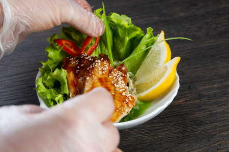 traditional Japanese salad of seaweed, eel in balsamic dressing. garnished with white sesame seeds and a lemon wedge. spicy salad with pepper. Japanese kitchen. salad in a white plate. the chef decorates the salad before servingの写真素材