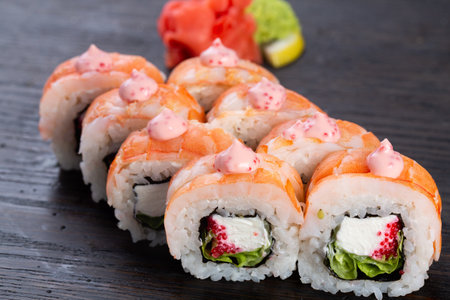 traditional Japanese sushi with shrimp and soft cheese, cucumber and red caviar, garnished with creamy sauce. Japanese kitchen. Japanese restaurant.の写真素材