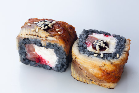 traditional Japanese cuisine. japanese sushi isolated on white background. maki sushi with eel, tomato, soft cheese (Philadelphia) and red caviar. black sushiの写真素材