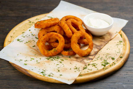 deep-fried onion rings in breading with creamy sauce. beer snack.の写真素材