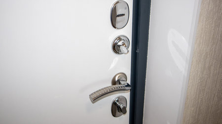 Door handle and door lock in white modern kitchen. close up.の写真素材