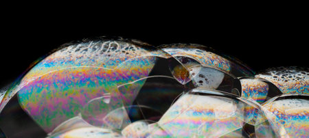 Coloful soap bubbles on black background isolated. Macro shot for design