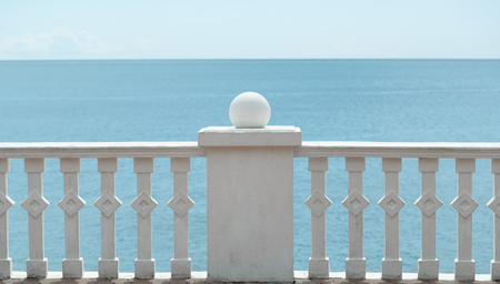 Stone white embankment in the form of a fence on the background of the sea and the horizon. In clear dayの写真素材