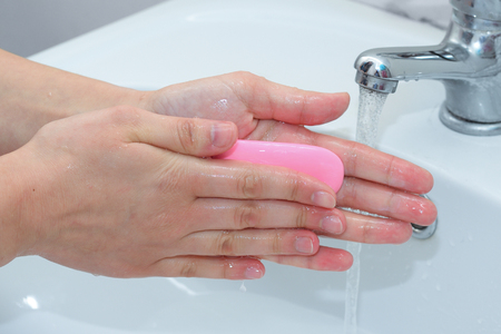washing hands with soap over the sinkの写真素材
