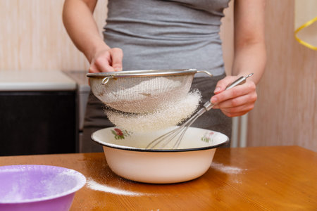 sifting flour for baking cookies through sieve