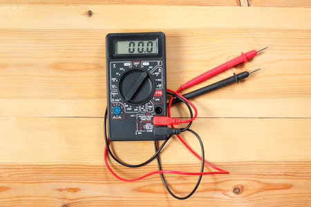 digital multimeter and wiring on wooden table. special tools of technician for work with circuit and...