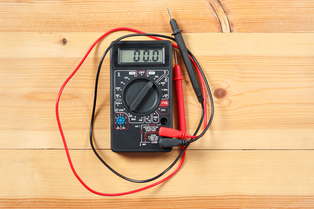 digital multimeter and wiring on wooden table. special tools of technician for work with circuit and electrical. technician use the digital multimeter in workshop for check and repair equipment.の写真素材