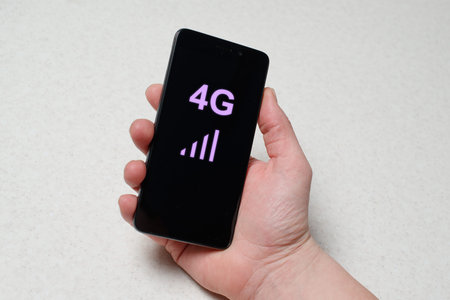European hand holding smartphone on the black background. 4g message is on the screen.