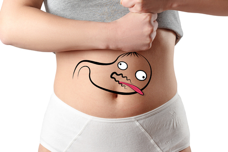 the concept of weight loss, fasting, weight loss, diet. Drawing of the stomach on the background of the woman's stomach, which she strangles with her hands. Isolated on white background. Studio photographyの写真素材