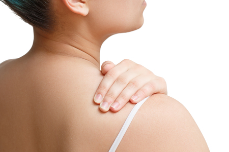 the woman massages the shoulder with her hand. the view from the back. isolated on white backgroundの写真素材