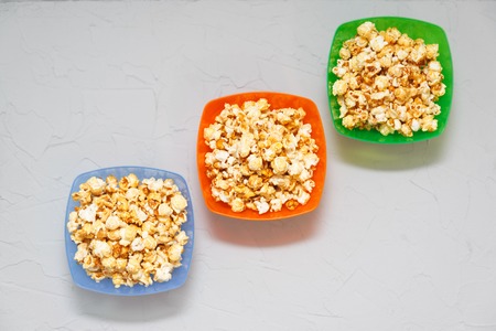 popcorn three colored plates on a neutral backgroundの写真素材