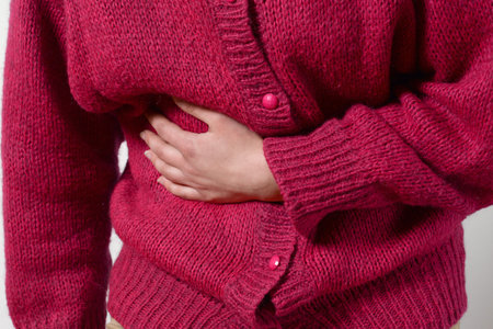 closeup photo. a woman has a pain in her stomach, and holds her hands. Concept of female medicine....