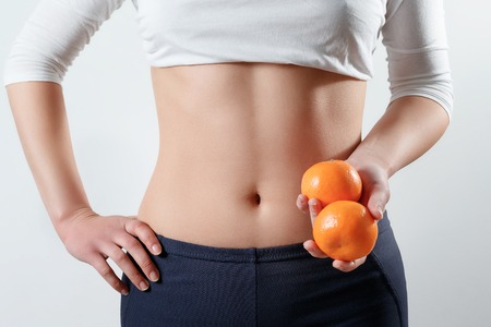 Figure of girl with citrus in hand on white backgroundの写真素材