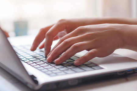 Woman working at home office hand on keyboard close up. contour light
