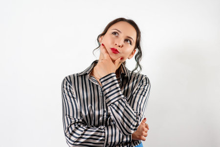 Thinking business woman looking up isolated on white backgroundの写真素材