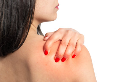 the woman massages the shoulder with her hand. the view from the back. isolated on white background