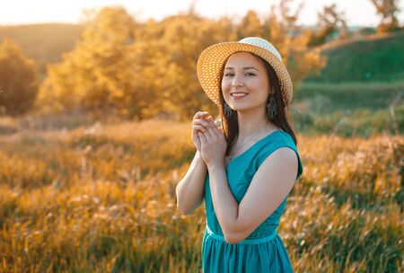 cute young woman girl enjoys warm summer sunset. bright summer portrait outdoor.の写真素材