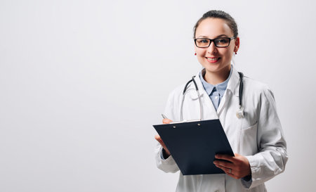 Portrait of a doctor woman in glasses with a stethoscope and clipboard on a white background....