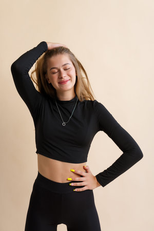 Portrait of a smiling young woman on a beige background