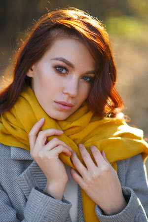 Portrait of beautiful young woman walking outdoors in autumn parkの写真素材