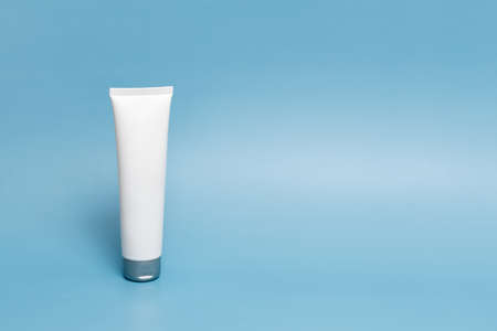 A mock-up of a plastic tube from a white survival bottle for branding medicines or cosmetics - cream, gel, toothpaste. A container for cosmetic bottles on a pastel blue background. Minimalismの写真素材
