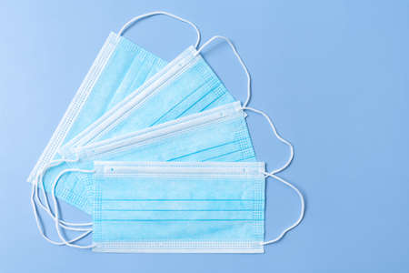Several face protective medical masks lying on a blue background.の写真素材