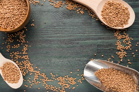 Wooden spoons and bowls with buckwheatの写真素材