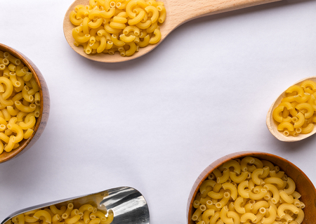 Wooden spoons and bowls with pastaの写真素材