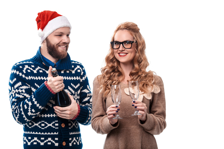 Beautiful couple having fun in hat Santa with champagne isolated on white backgroundの写真素材