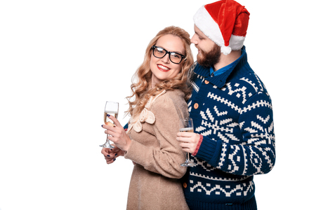 Beautiful couple having fun in hat Santa with champagne isolated on white backgroundの写真素材