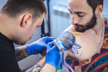 Tattooist makes a tattoo. Closeupの写真素材