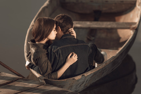 Happy romantic couple rowing a small boat on lakeの写真素材