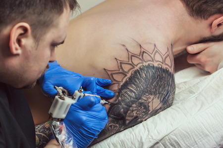 Tattooist makes a tattoo. Closeupの写真素材