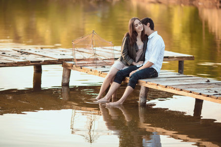Couple on the wooden jetty at a lakeの写真素材