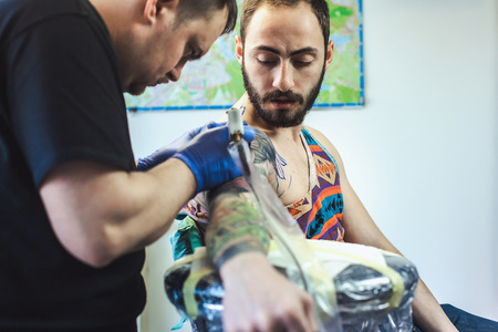 Tattooist makes a tattoo. Closeupの写真素材
