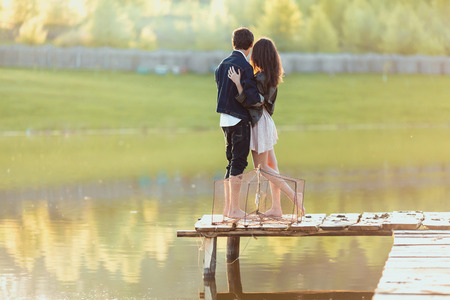 Couple on the wooden jetty at a lakeの写真素材