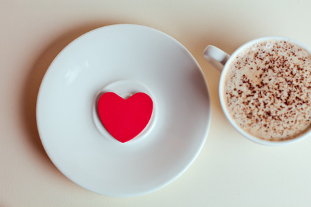 Beautiful coffee Cup with heart cupcake on white wooden backgroundの写真素材